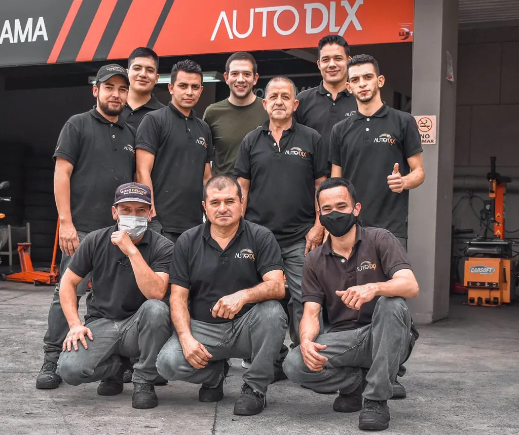 El equipo crecido en 2023 frente al taller, bajo el aviso rojo y negro de Auto DLX